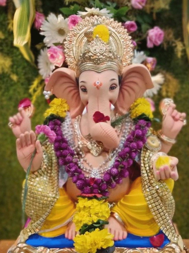 ganesh idol decorated with flowers and lamps for ganesh chaturthi celebration